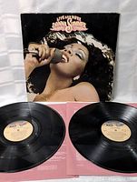 Photo of album cover and two vinyl records laid out showing front cover art and vinyl condition.