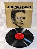 Photo of vinyl record and album cover showing cover wear and record condition.