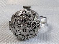 Front view of silver tone vintage MCM Samba watch ring with ornate filigree cover and black accents.