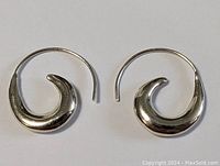 Pair of silver curled earrings displayed side-by-side on a white background, showing full design and shape.