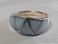 Close up of the sterling silver ring showing blue inlay and band.