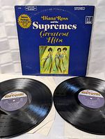 Photo of the front album cover alongside two vinyl records showing Motown labels.