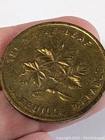 Front side of coin with maple leaf design and bilingual text