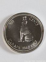Front side of the 1967 Canada silver 50 cents coin showing seated howling wolf design and inscription 'CANADA 1867-1967'