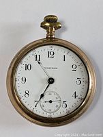 Front view of Waltham gold filled pocket watch showing white dial with black numerals and missing crystal cover