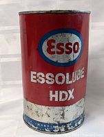 Front view of the vintage Esso HDX Essolube oil tin with red, white and blue branding and scattered wear.