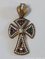 Full view of vintage sterling silver cross pendant with multiple gemstones and clear stones.