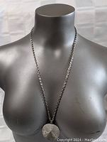 Full view of pendant necklace on mannequin torso.