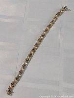 Full view of the sterling silver bracelet laid out straight, showing the whole length and clasp.