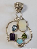 Clear view of the pendant featuring multiple bezel-set gemstones and the decorative silver bail.