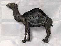 Full view of the brass ashtray shaped like a camel with visible 'CAMEL' text on the tray section