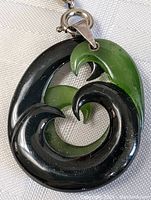 Close-up of jade pendant showcasing swirl black and green jade carving and sterling clasp
