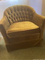 Front view of green fabric armchair showing tufted backrest and cushion seat