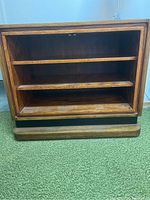Front angle view of open wooden shelf showing three evenly spaced shelves inside the rectangular frame and wood grain finish
