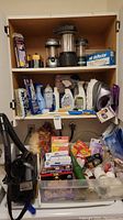 Photo showing shelves holding household cleaning products, handheld vacuum, steam scrubber, cleaning sprays, and batteries.