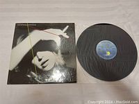 Vinyl record and album cover sleeve showing the front and record out of sleeve.