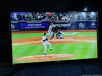 Front of RCA 32-inch LED TV displaying a baseball game on screen.