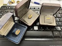 Three British Columbia Railway service pins displayed in individual boxes placed on a keyboard, with visible branding inside boxes and pin details.