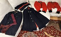 Full display of all dress uniform items on white couch and a patterned carpet.