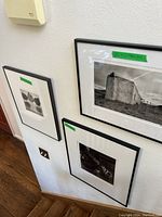 Three framed black & white photographs in black frames with white mats mounted on wall