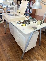 Front view showing art table, lamps, supplies on tabletop