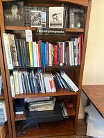 Full frontal view of wooden bookcase showing all five shelves and contents