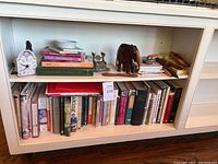 Bookshelves filled with multiple cookbooks and some small home decor items.