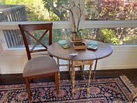 Table and chair set by window with decorative items on table