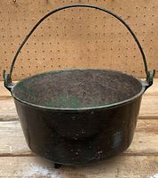 Side view showing black painted exterior and metal handle for carrying.