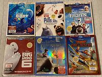 Photo showing all six movie cases arranged side by side: Finding Dory, Secret Life of Pets, Frozen, Big Hero 6, Tinkerbell and the NeverBeast, Planes Fire & Rescue