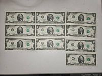 Front side of 10 sequential $2 bills arranged in grid, showing Thomas Jefferson and serial numbers.