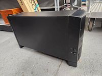 Side view of black Bose Acoustimass speaker system module showing power and control knobs.