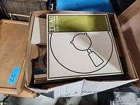 Box containing several TEAC branded reel to reel tape boxes and empty plastic reels, including a TEAC RE-1000MkII box visible on top.