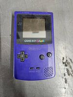 Front view of purple Nintendo Game Boy Color handheld console showing screen, control buttons and front details.
