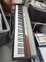 Full view of Korg SP-250 keyboard showing the full set of keys, wood panel accents, and control layout.