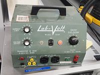 Front view of Labvolt 354P showing control knobs, power switch, indicator light, and output terminals with labels.