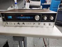 Front view of Pioneer QX-4000 receiver showing tuning display, meters, control knobs, and wood casing.