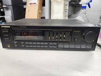 Front full view of the Pioneer SX-1300 stereo receiver showing display and buttons.