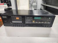 Full front view of the black TEAC stereo cassette deck showing power button, cassette window, and control buttons below.