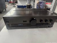 Front view of Technics integrated amplifier showing controls, power switch, and input display.