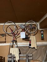 Maroon Giant brand road bike hung upside down with a MAXSOLD label visible.