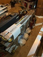 Side angled view of the folded Aluminum Gorilla Ladder MPX22W with visible yellow wheels and black/yellow branding label.