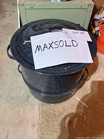 Top view of graniteware steaming/canning pot with lid, showing black speckled enamel with handles.