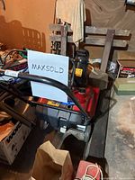 Photo of the Toro snow blower showing handle and chute with snow discharge direction sticker, black wheels, and red body.