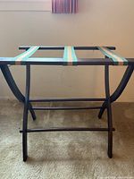 Front view of vintage wooden luggage rack showing the dark wood frame and fabric straps.