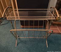 Front angled view of brass magazine rack with faux bamboo detail and glass top