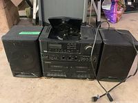 Photo of the full boom box showing both detachable speakers, CD player lid open, control panel, and power cord.