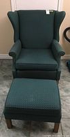 Fabric upholstered wingback chair with matching ottoman shown together, highlighting the set and upholstery details.