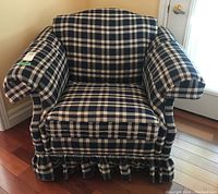 Front view of the plaid upholstered armchair showing removable cushioned seat and pleated fabric skirt