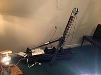 Partially disassembled NordicTrack ski machine exercise equipment leaning against a wall with manuals on the floor and cables visible.